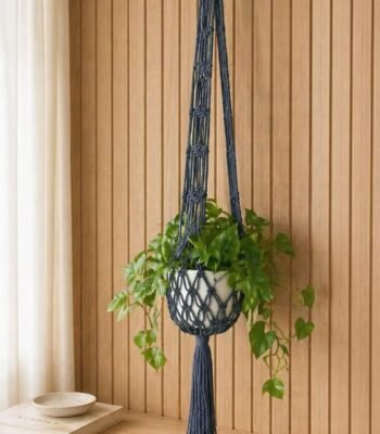 Handmade dark macramé plant hanger with indoor green plant and decorative planter