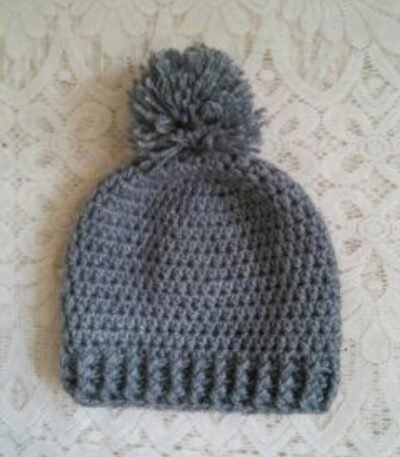 Handmade grey crochet pom pom beanie cap with textured pattern and ribbed edge